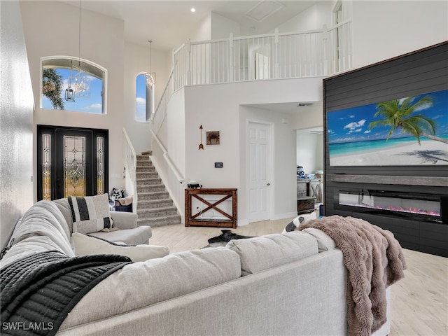 living room with hardwood / wood-style flooring and a towering ceiling