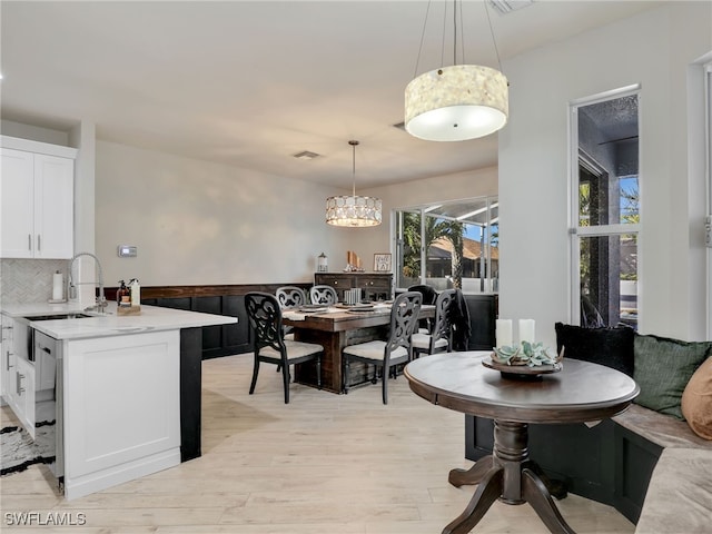 dining room with sink and light wood-type flooring