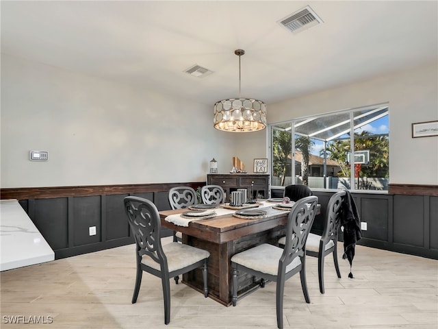 dining area featuring a notable chandelier and light wood-type flooring