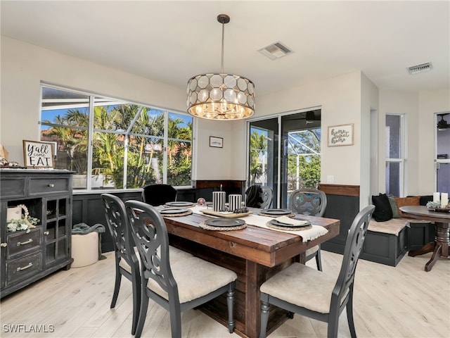 dining area featuring plenty of natural light, a notable chandelier, and light hardwood / wood-style flooring