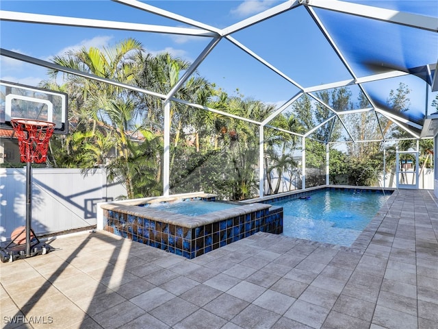 view of pool featuring an in ground hot tub, pool water feature, a patio area, and glass enclosure