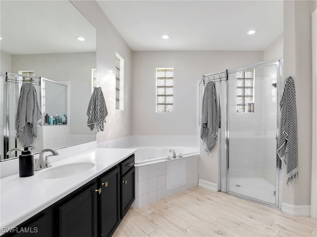 bathroom with hardwood / wood-style flooring, vanity, and separate shower and tub