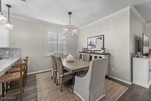 dining space featuring a notable chandelier, crown molding, and dark hardwood / wood-style floors