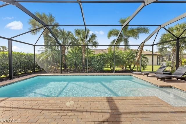 view of swimming pool with a patio and glass enclosure