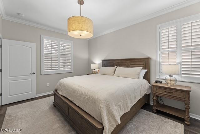 bedroom with dark wood-type flooring and ornamental molding