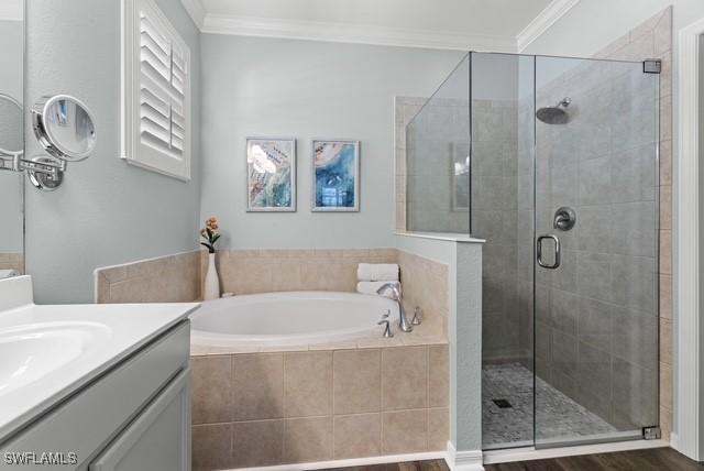 bathroom featuring crown molding, vanity, independent shower and bath, and hardwood / wood-style flooring