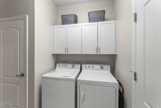 laundry area with cabinets and washer and clothes dryer