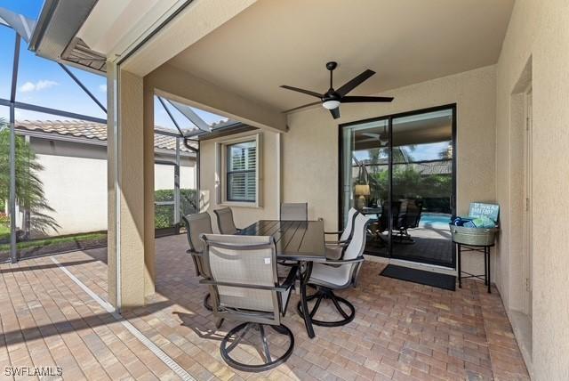 view of patio with ceiling fan and glass enclosure