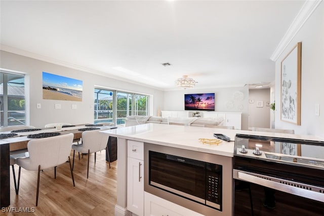 kitchen featuring crown molding, open floor plan, visible vents, and built in microwave