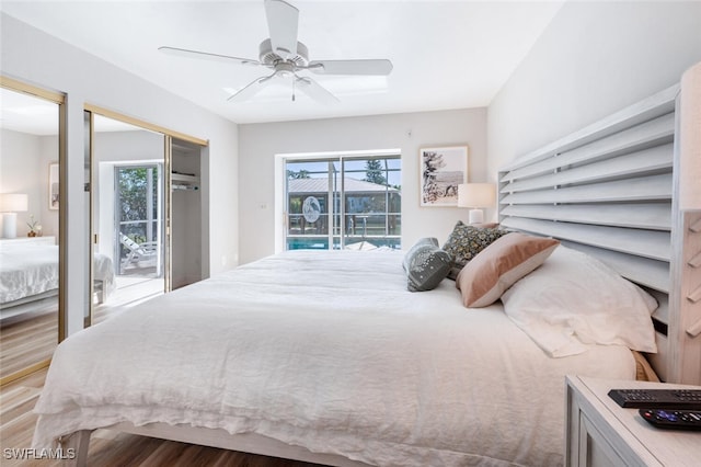 bedroom featuring wood finished floors, access to outside, multiple windows, and a ceiling fan