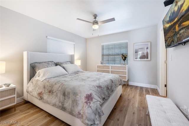 bedroom featuring baseboards, wood finished floors, and a ceiling fan