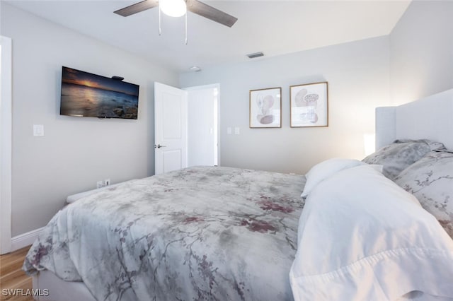 bedroom with a ceiling fan, visible vents, light wood finished floors, and baseboards