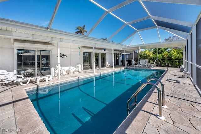 pool with a patio area and glass enclosure