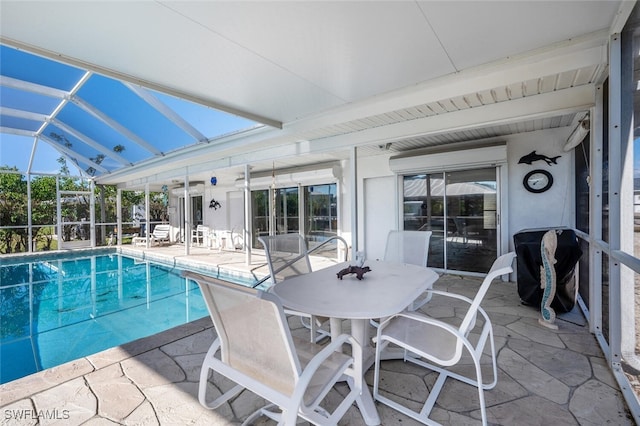 outdoor pool with glass enclosure and a patio area