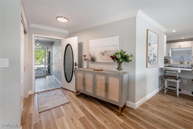 foyer with crown molding, recessed lighting, baseboards, and light wood finished floors