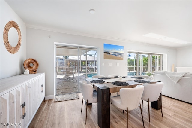 dining room featuring light wood-style floors and crown molding