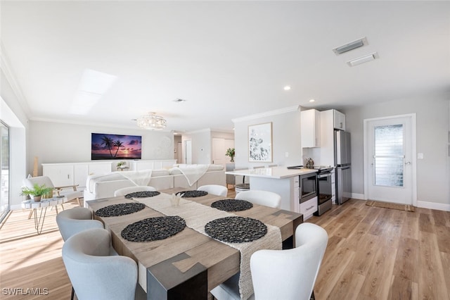 dining area featuring baseboards, visible vents, light wood finished floors, recessed lighting, and crown molding