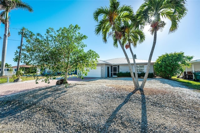 view of front facade featuring decorative driveway and an attached garage