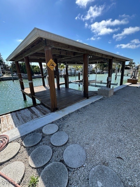 dock area with a water view and boat lift