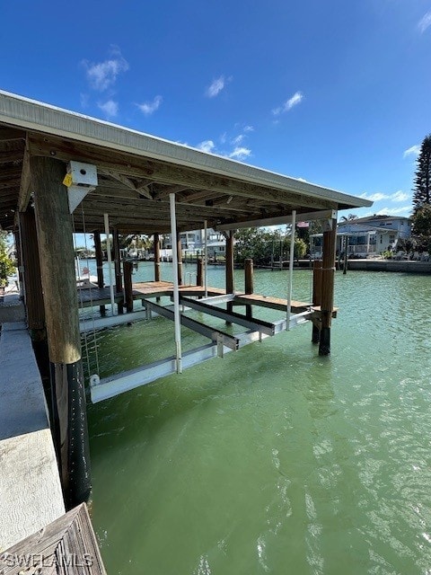 dock area with boat lift and a water view