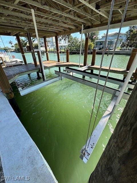 dock area with boat lift and a water view