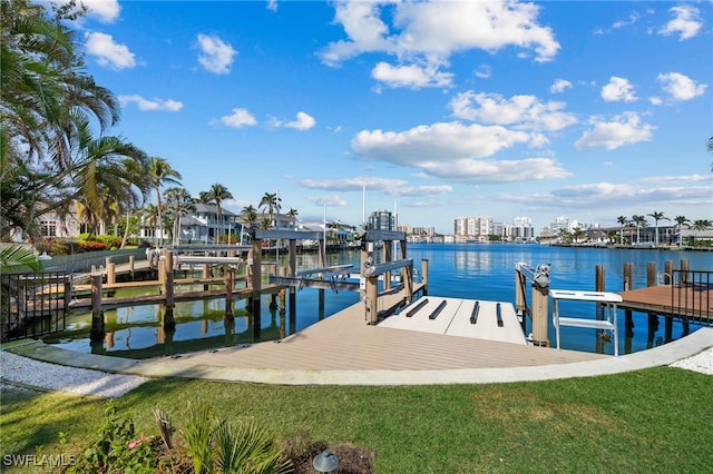 view of dock with a yard and a water view