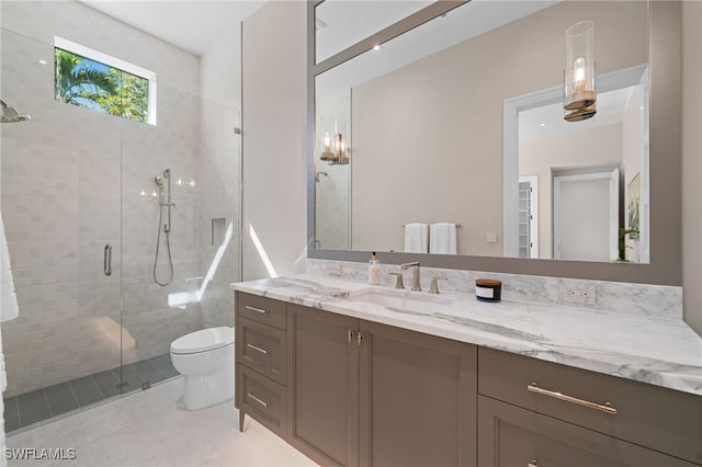 bathroom with a shower with door, vanity, tile patterned flooring, and toilet