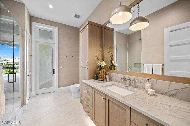 bathroom featuring vanity, toilet, and a shower with door