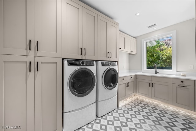 washroom featuring cabinets, sink, and washer and dryer