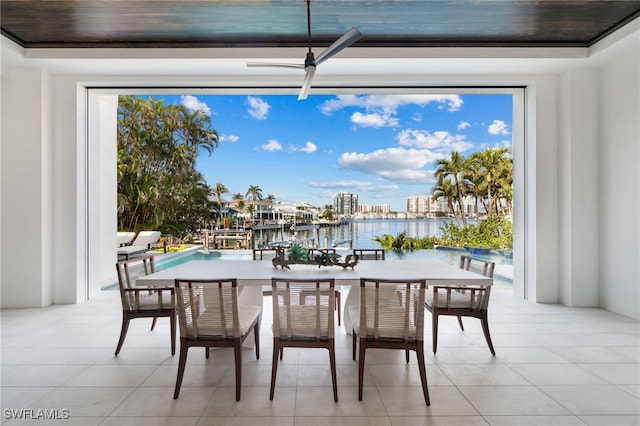 dining area featuring light tile patterned floors and a water view