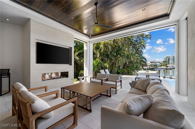 view of patio featuring ceiling fan and an outdoor living space with a fireplace