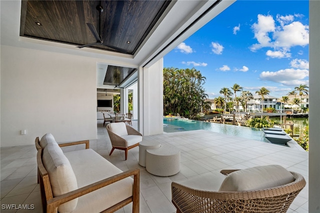 view of patio / terrace with an outdoor living space, a water view, and ceiling fan