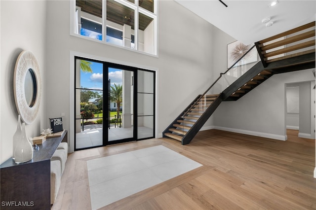 entryway with a high ceiling and light hardwood / wood-style floors