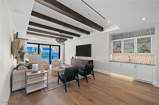 living room featuring beam ceiling, wood-type flooring, and indoor wet bar