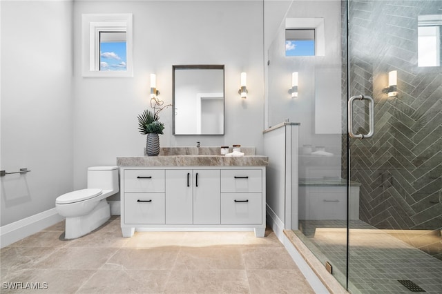 bathroom featuring tile patterned floors, vanity, toilet, and a shower with shower door