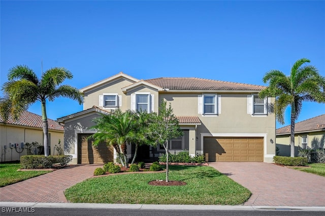 view of front facade featuring decorative driveway, an attached garage, stucco siding, and a tiled roof