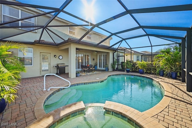 view of pool with a lanai, grilling area, a patio, and an in ground hot tub