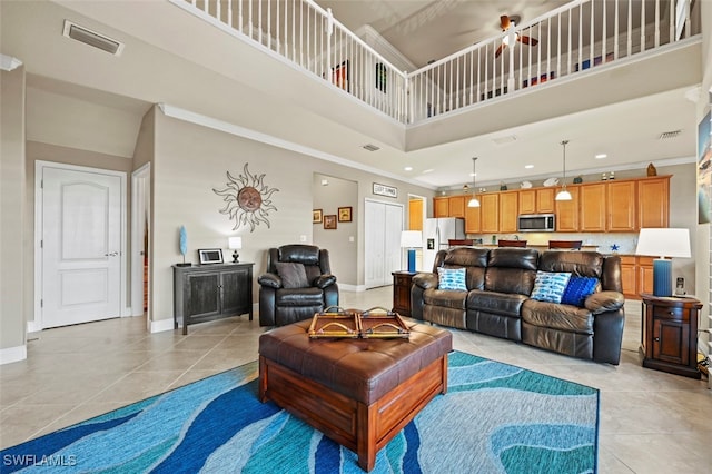 tiled living room featuring a high ceiling and ornamental molding