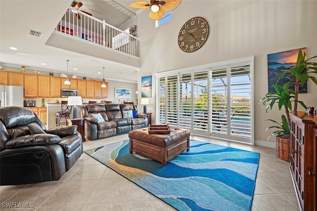 tiled living room featuring ceiling fan and a high ceiling