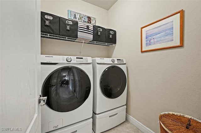 laundry area with separate washer and dryer and light tile patterned floors