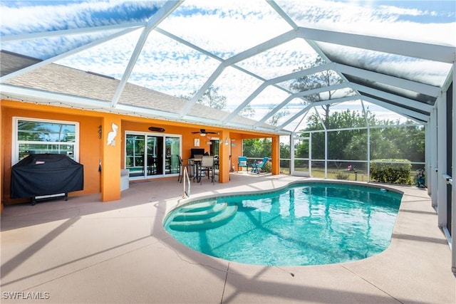 view of swimming pool with ceiling fan, a grill, a lanai, and a patio