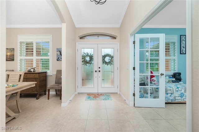 tiled entrance foyer with ornamental molding, a wealth of natural light, and french doors