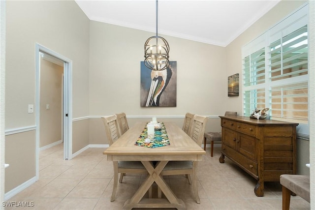 tiled dining space featuring ornamental molding and a chandelier