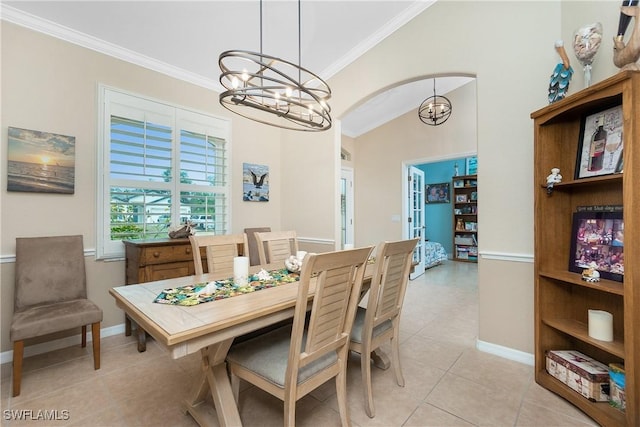 tiled dining area featuring lofted ceiling, ornamental molding, and a chandelier