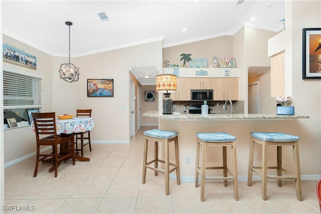 kitchen featuring decorative light fixtures, kitchen peninsula, crown molding, light stone countertops, and light brown cabinets