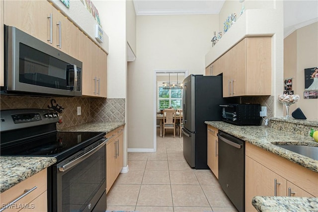 kitchen featuring light brown cabinetry, light stone countertops, crown molding, and stainless steel appliances