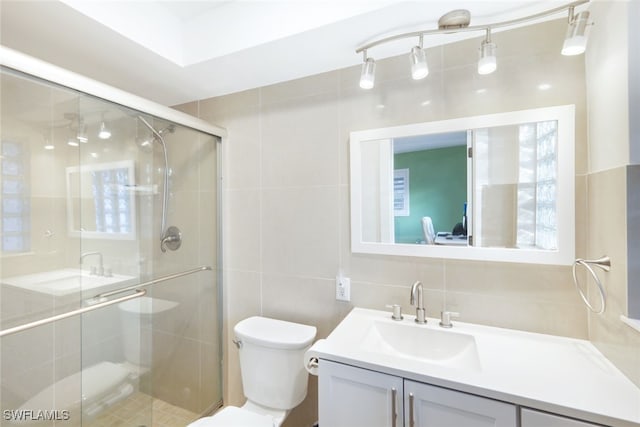 bathroom featuring tile walls, vanity, toilet, and walk in shower