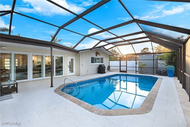 view of pool with a shed, area for grilling, a lanai, and a patio area