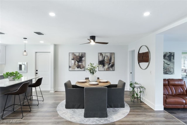 dining area with hardwood / wood-style floors and ceiling fan