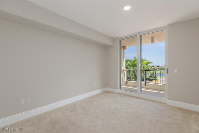 unfurnished room featuring expansive windows and light carpet